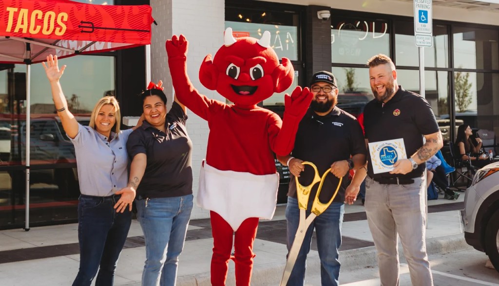 Exterior of a Torchy's Tacos restaurant with staff outside